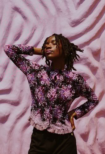 Black Girl With Dreadlocks Wearing A Purple And Black Top