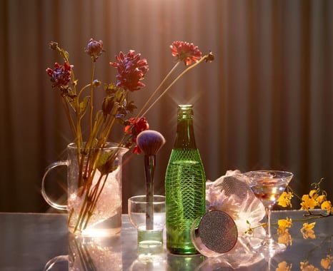 Modern feminine still life of glass of white wine and various items on the dressing table