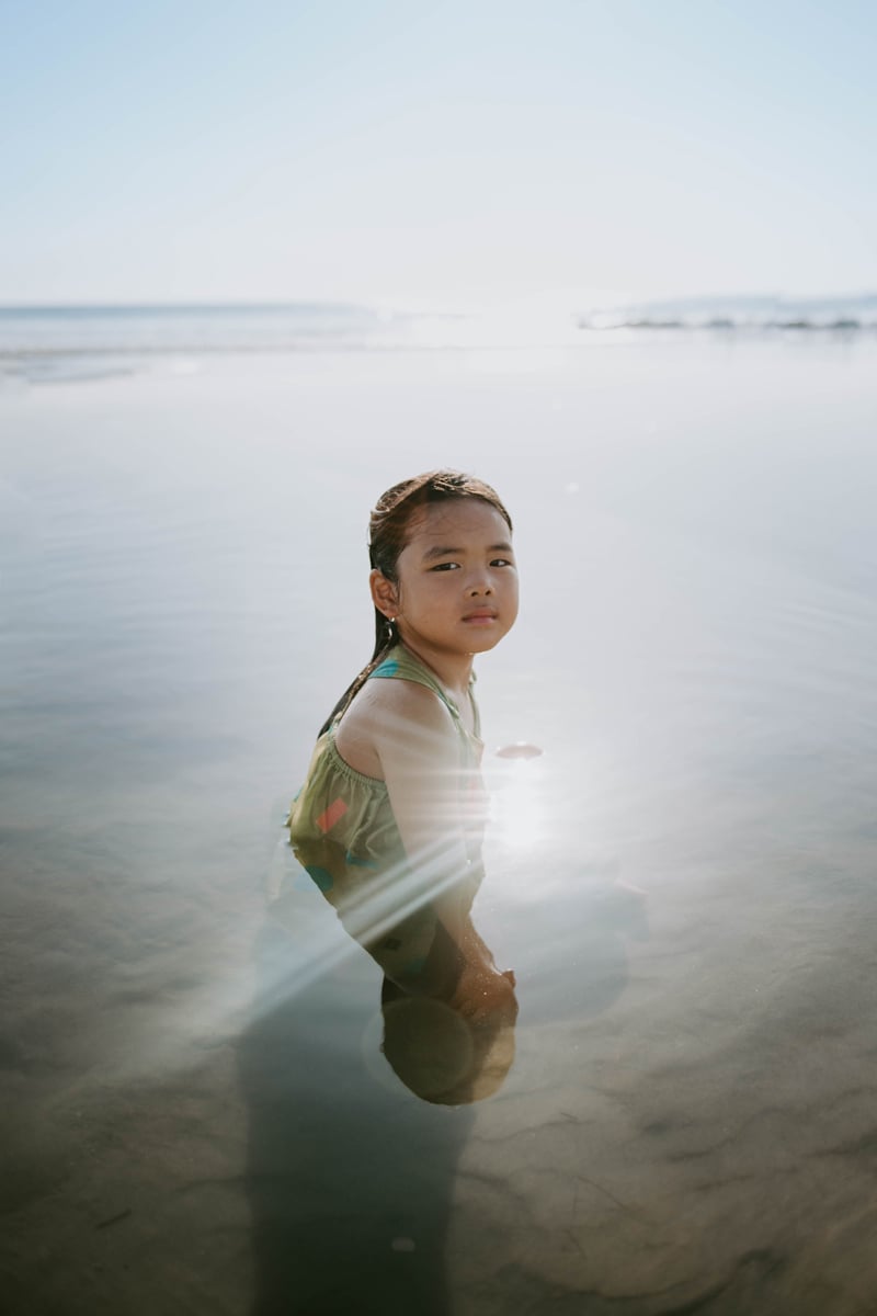 Beautiful Girl Sitting In Water With Sunlight.