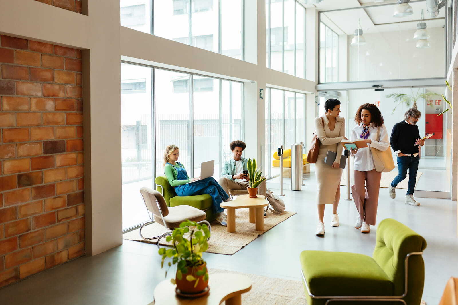 Business People Walking And Talking In A Hallway Busy businesswomen discussing together while walking in modern office