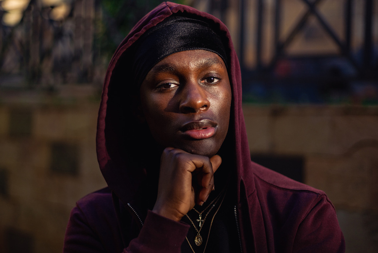 Portrait of a black man being pensive/looking into the distance.