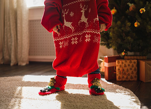 Crop of child with oversized Christmas Sweater